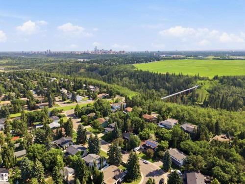Aerial perspective of a residential neighborhood with a distant cityscape, expansive green spaces, and a river valley - 14307 50 Avenue Nw, Edmonton, AB 