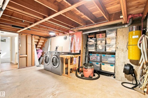 Basement space featuring exposed wood joists, concrete flooring, laundry appliances, and a built-in central vacuum system - 14307 50 Avenue Nw, Edmonton, AB 