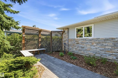 Paver walkway leading to a wooden trellis with integrated seating - 14307 50 Avenue Nw, Edmonton, AB 