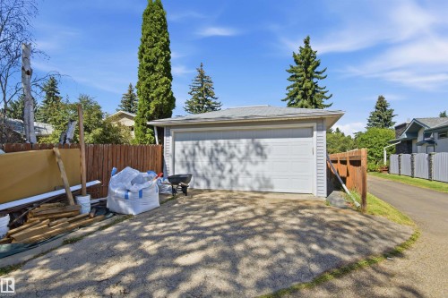 Detached garage with a paneled door and light gray siding, featuring a gravel driveway - 14307 50 Avenue Nw, Edmonton, AB 
