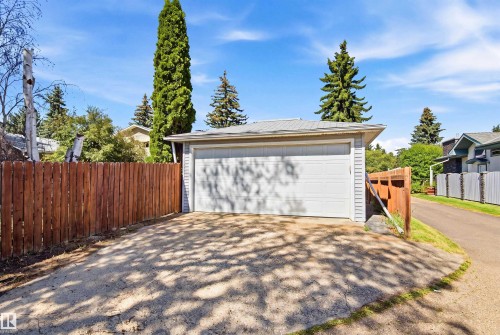 Detached garage with a roll-up door, siding exterior, and metal roof - 14307 50 Avenue Nw, Edmonton, AB 