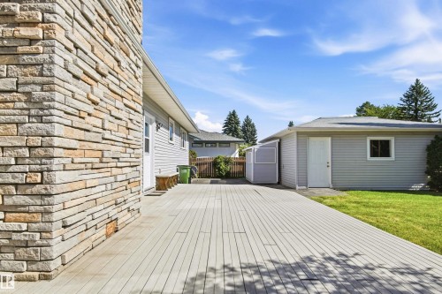 Expansive composite deck leading to a detached garage with vinyl siding - 14307 50 Avenue Nw, Edmonton, AB 