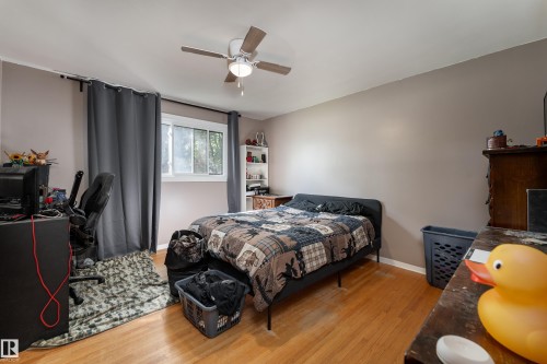 Hardwood flooring, painted walls, ceiling fan with integrated lighting, window with drapes, and built-in shelving - 14906 76 Avenue Nw, Edmonton, AB 