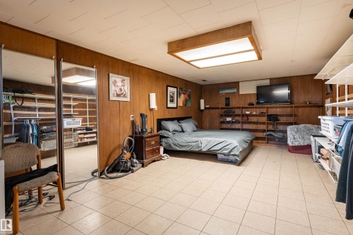Wood-finish wall paneling, tiled flooring, built-in shelving, and recessed ceiling lighting - 14906 76 Avenue Nw, Edmonton, AB 