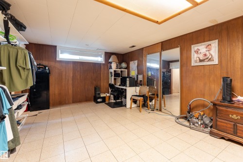 Tile flooring with a neutral finish, wood-paneled walls, and a recessed ceiling light fixture - 14906 76 Avenue Nw, Edmonton, AB 