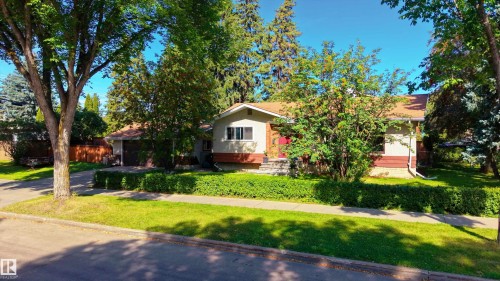 Exterior residence with a light-toned facade and a red front door - 14906 76 Avenue Nw, Edmonton, AB 
