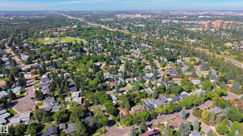 Residential neighborhood with extensive tree canopy, grid street pattern, and distant urban skyline - 14906 76 Avenue Nw, Edmonton, AB 