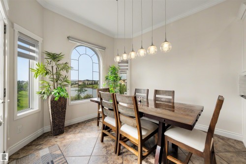 Dining area with an arched window, a multi-light pendant fixture, and large format floor tiles - 282 Ozerna Road Nw, Edmonton, AB 