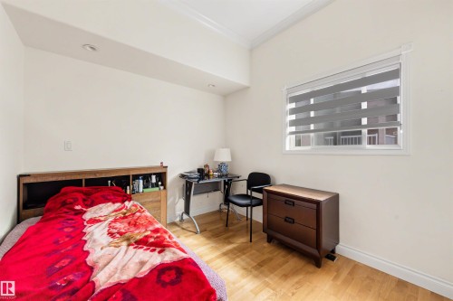 Light-toned wood-finish flooring, white walls, recessed ceiling lighting, crown molding, and a window with blinds - 282 Ozerna Road Nw, Edmonton, AB 