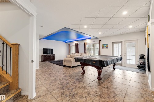 Recreational living space featuring tiled flooring, a decorative drop ceiling with accent lighting, and recessed lighting - 282 Ozerna Road Nw, Edmonton, AB 