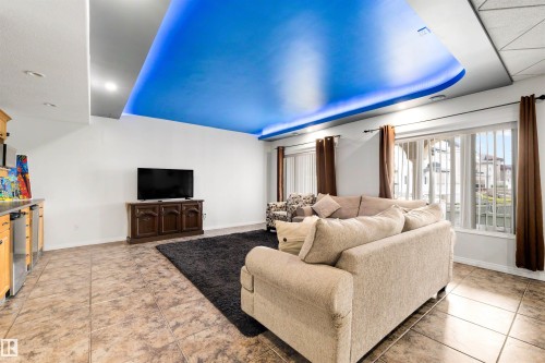 Recessed ceiling lighting, tile flooring, built-in cabinetry with stainless-steel accents, and large windows with vertical blinds - 282 Ozerna Road Nw, Edmonton, AB 