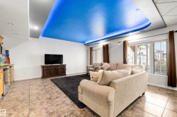 Recessed ceiling lighting, tile flooring, built-in cabinetry with stainless-steel accents, and large windows with vertical blinds - 