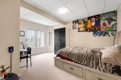 Recessed lighting, wall-to-wall carpeting, and a built-in wardrobe with dark wood-finish doors - 