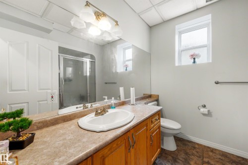 Vanity with wood-finish cabinetry, integrated sink, and laminate countertop - 282 Ozerna Road Nw, Edmonton, AB 