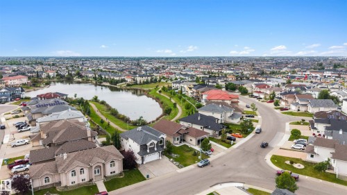 Community with a central pond, residential streets, and varied architectural styles - 282 Ozerna Road Nw, Edmonton, AB 