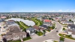 Community with a central pond, residential streets, and varied architectural styles - 