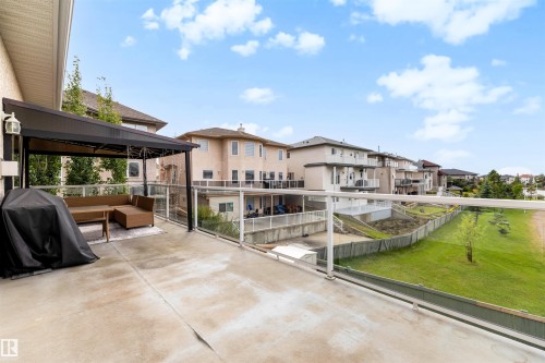Expansive outdoor deck with a permanent pergola structure, glass panel railings, and a concrete surface - 282 Ozerna Road Nw, Edmonton, AB 