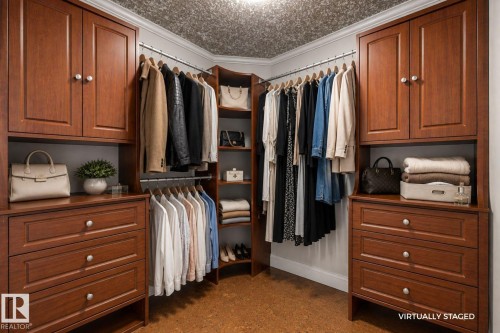 Built-in wood-finish cabinetry, integrated hanging rods, multiple drawer banks, corner shelving unit, and textured ceiling treatment - 282 Ozerna Road Nw, Edmonton, AB 