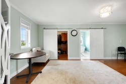 Window with white trim, wood-finish flooring, white barn doors, and overhead decorative lighting - 