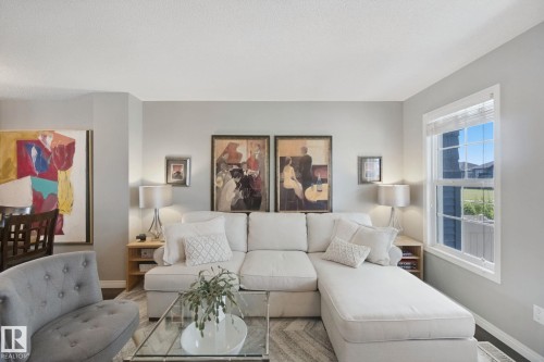 Recessed lighting, wood-finish flooring, and a large window with white trim - #58 4029 Orchards Dr Sw, Edmonton, AB 