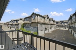 Balcony with metal railing overlooking a paved parking area - 