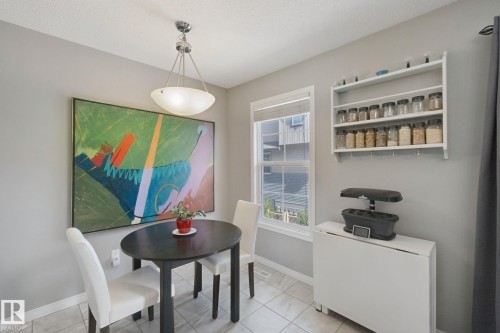 Recessed ceiling light fixture with a glass bowl shade, a white window frame, and a wall-mounted shelving unit - #58 4029 Orchards Dr Sw, Edmonton, AB 