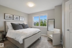 Carpeted bedroom featuring a flush mount ceiling light, multiple-pane window, and painted interior door - 