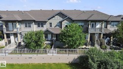 Multi-level townhome featuring a neutral exterior, private balconies, and individual fenced patios - 