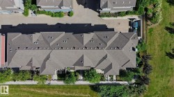 Townhome property featuring a shingle roof and multiple skylights - 