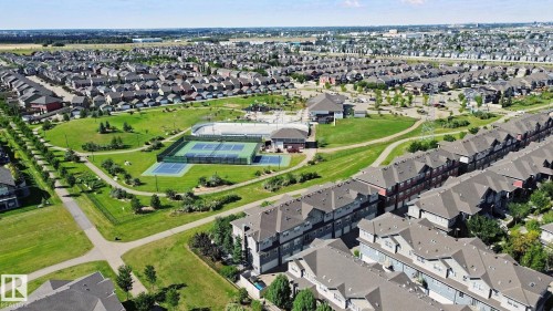 Expansive community green space with paved walking paths, multiple tennis courts, and mature landscaping - #58 4029 Orchards Dr Sw, Edmonton, AB 