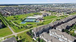Expansive community green space with paved walking paths, multiple tennis courts, and mature landscaping - 