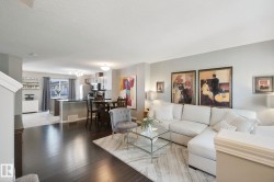 Open-concept living space with dark wood-finish flooring, light grey wall tones, and recessed lighting - 