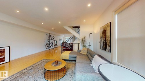 Recessed ceiling lighting, wood-finish flooring, white wall finishes, and a staircase with open risers - 9846 112 Street Nw, Edmonton, AB 