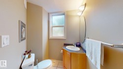 Bathroom featuring a window, built-in vanity with wood-finish cabinetry, countertop with an integrated sink, wall-mounted mirror, and tile flooring - 