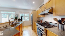 Kitchen featuring wood cabinetry, stainless steel appliances, a double basin sink, and recessed lighting - 