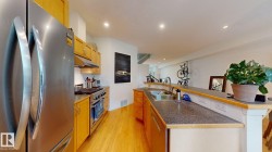Kitchen featuring stainless steel appliances, wood-finish flooring, recessed lighting, wood cabinetry, and a double basin sink - 