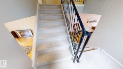 Carpeted staircase with wrought iron balusters - 