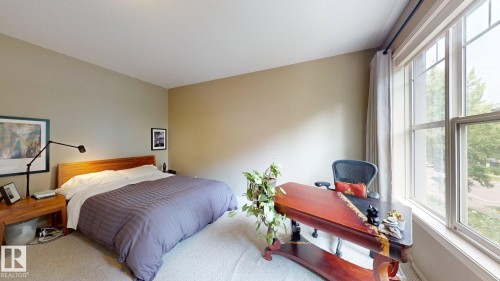 Carpet flooring, neutral wall paint, and a large multi-pane window with drapery rod - 9846 112 Street Nw, Edmonton, AB 
