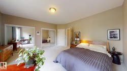 Carpeted bedroom with neutral wall tones, dual mirrored closet doors, and recessed lighting - 