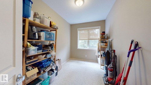 Carpeted room with a window, neutral wall paint, and a ceiling-mounted light fixture - 9846 112 Street Nw, Edmonton, AB 