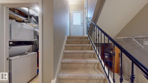 Carpeted staircase with black wrought iron railing - 9846 112 Street Nw, Edmonton, AB 