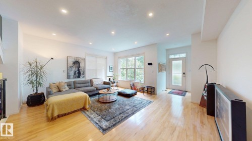 Hardwood flooring, recessed lighting, expansive windows, a solid panel entry door with frosted glass, and white walls - 9846 112 Street Nw, Edmonton, AB 