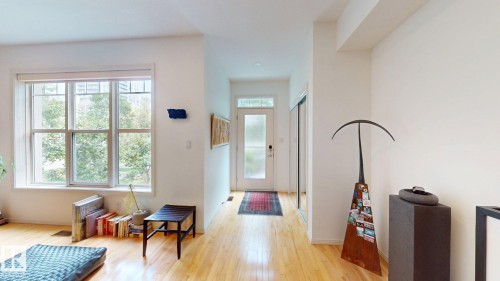 Light wood-finish flooring, a large multi-pane window, and a glass-paneled entry door - 9846 112 Street Nw, Edmonton, AB 