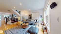 Bright, open-concept living space featuring hardwood flooring, recessed lighting, and abundant natural light from large windows - 