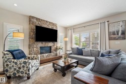 Stone-clad fireplace with a wood mantel and recessed electric insert - 