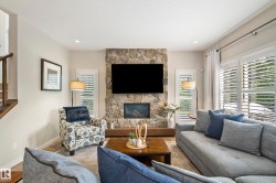 Stone-clad fireplace with built-in hearth and integrated television - 