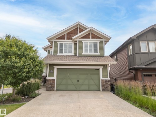 Two-story residence featuring green siding, a gable roof with shingle accents, and an integrated two-car garage - 5966 Edmonds Crescent Nw, Edmonton, AB - Outdoor