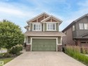Two-story residence featuring green siding, a gable roof with shingle accents, and an integrated two-car garage - 5966 Edmonds Crescent Nw, Edmonton, AB  - Outdoor 