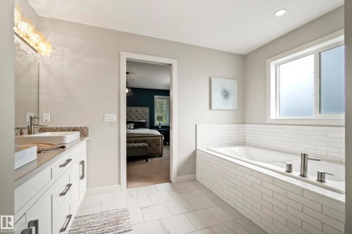 Contemporary bathroom featuring a built-in tub with subway tile surround, a frosted window, and a vanity with a vessel sink - 5966 Edmonds Crescent Nw, Edmonton, AB - Indoor Photo Showing Bathroom