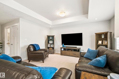 Living area featuring a tray ceiling, recessed lighting, and light-toned carpeting - 5966 Edmonds Crescent Nw, Edmonton, AB - Indoor Photo Showing Living Room